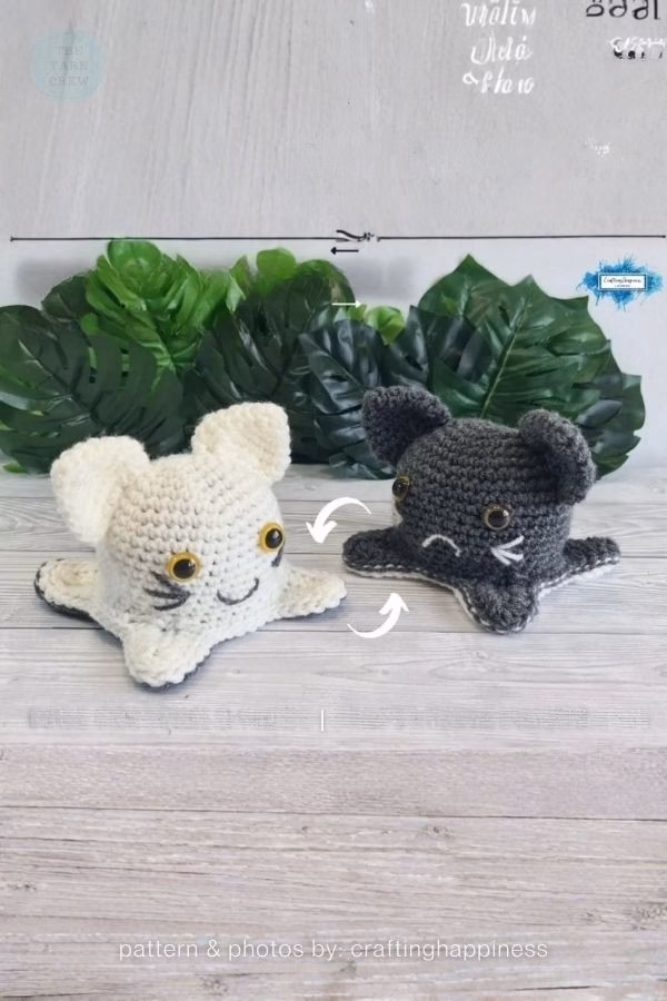 A reversible crochet plushie showing both its cream-colored happy face and its dark gray grumpy face side-by-side; from a roundup on TheYarnCrew by Ariana Wimsett.