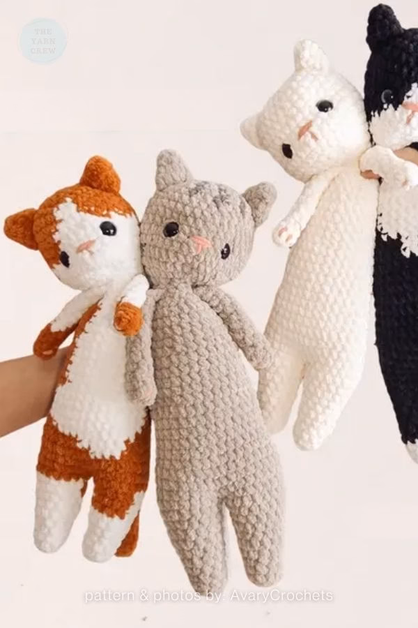 Four long, slender crochet cats in various colors, including tabby, gray, cream, and tuxedo; from a roundup on TheYarnCrew by Ariana Wimsett.