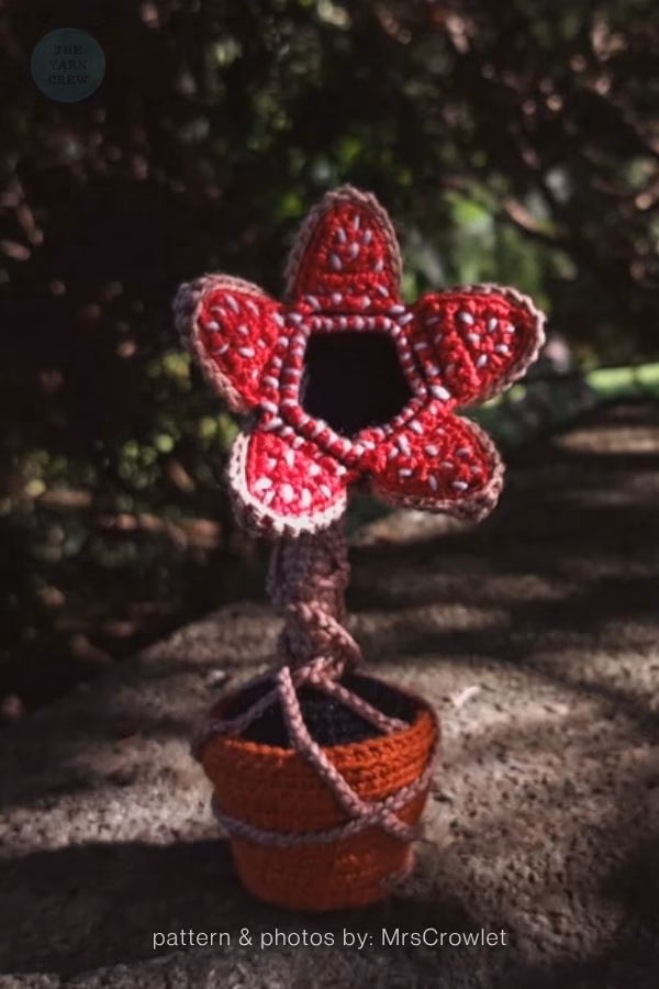 A crochet toy of a Demogorgon from Stranger Things made to look like a plant sitting inside a small orange pot. Curated by Ariana of TheYarnCrew.