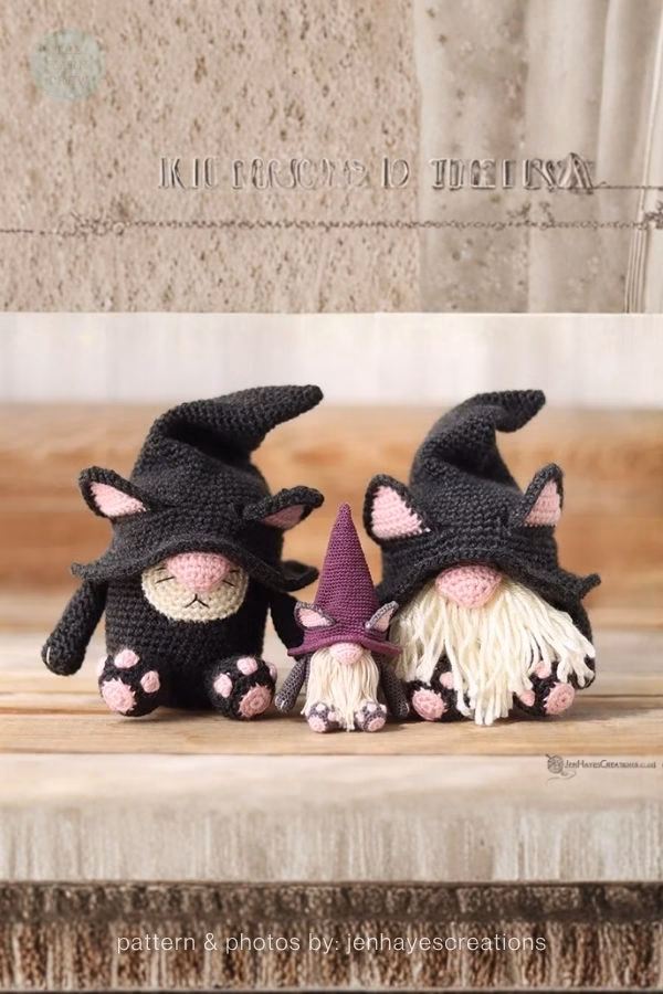 Three crocheted gnomes dressed in black cat costumes with pointed hats and pink paw prints; from a roundup on TheYarnCrew by Ariana Wimsett.