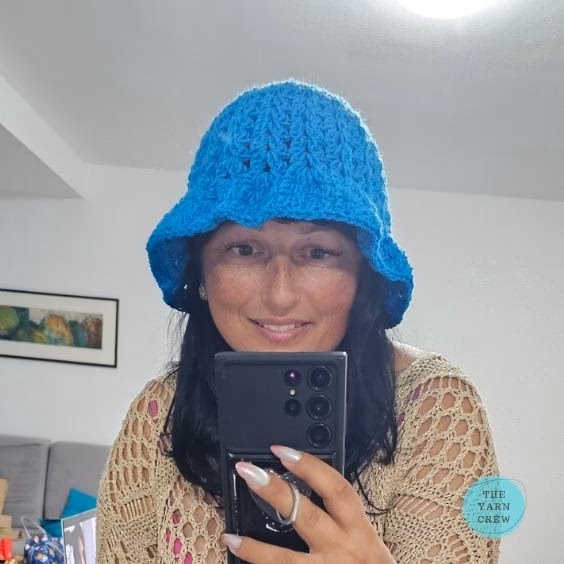 Bright blue crochet bucket hat made with a textured stitch pattern. Original design created by Ariana Wimsett at TheYarnCrew.com.